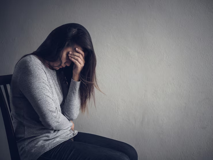 Pessoa reflexiva olhando pela janela, ilustrando o esvaziamento da depressão